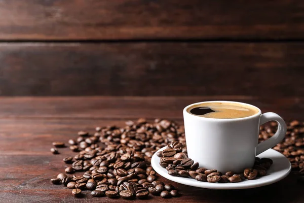 Tasse Heißen Aromatischen Kaffee Und Geröstete Bohnen Auf Einem Holztisch — Stockfoto