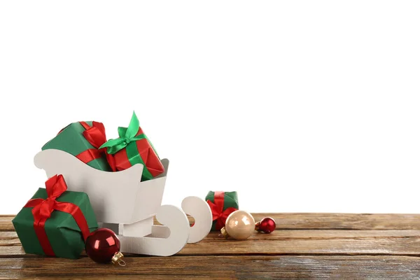 Dekorativer Schlitten Mit Geschenkschachteln Und Weihnachtskugeln Auf Holztisch Raum Für — Stockfoto