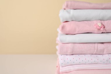 Küçük kızın kıyafetleri beyaz masaya yığılmış, yakın plan. Metin için boşluk