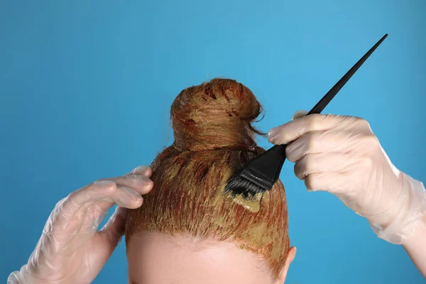 Junge Frau Färbt Ihre Haare Mit Henna Auf Hellblauem Hintergrund — Stockfoto
