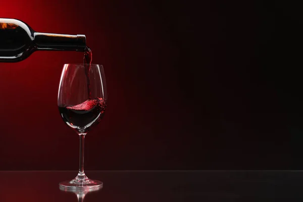 Ρίχνει Κόκκινο Κρασί Από Μπουκάλι Ποτήρι Σκούρο Φόντο Χώρος Για — Φωτογραφία Αρχείου