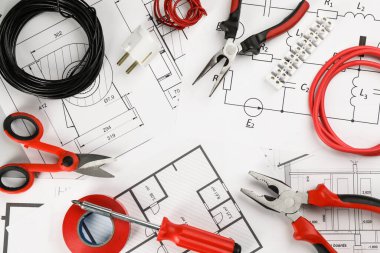 Elektrikçi aletleri ile düz kompozisyon ve masa üzerinde ev planı kağıtları