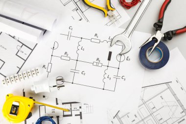 Elektrikçi aletleri ile düz kompozisyon ve masa üzerinde ev planı kağıtları