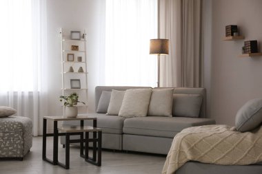 Pencereye yakın rahat kanepesi olan modern oturma odası.