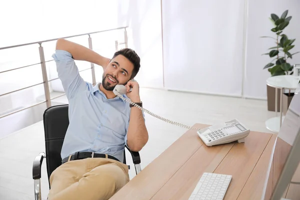 職場のオフィスチェアで電話で話すリラックスしたビジネスマン — ストック写真
