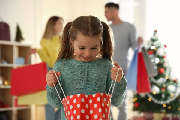 両親のそばに袋を持った少女が店にいる ファミリークリスマスショッピング — ストック写真