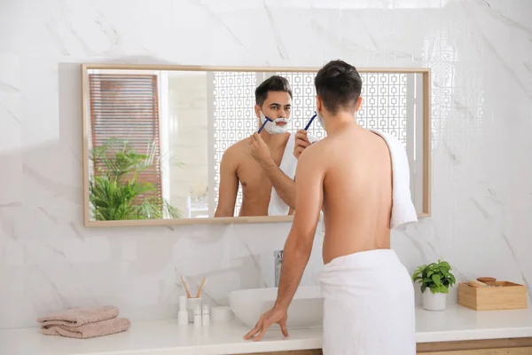 Όμορφος Νεαρός Άνδρας Ξυρίζεται Ξυράφι Κοντά Στον Καθρέφτη Στο Μπάνιο — Φωτογραφία Αρχείου