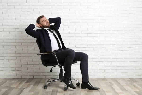 Junger Mann Sitzt Bürostuhl Neben Weißer Ziegelwand Innenraum Platz Für — Stockfoto