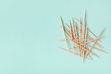 Açık mavi arka planda tahta kürdanlar, düz yatış. Metin için boşluk