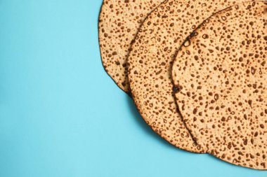 Açık mavi arkaplanda leziz matzolar, metin için yeri olan düz yataklar. Hamursuz Bayramı (Pesach) kutlaması