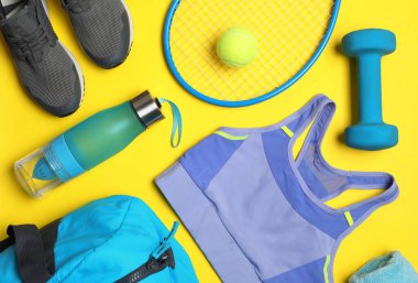 Düz kompozisyon ve sarı arka planda spor ekipmanları