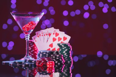 Alkol içecekleri, zar, kumar kartları ve kumarhane fişleri bulanık ışıklara karşı, mesaj için yer. Düz poker kombinasyonu