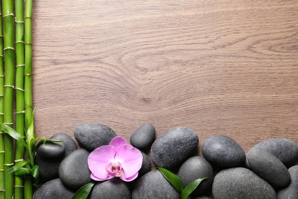 Kamienie Uzdrowiskowe Piękny Kwiat Storczyka Bambusa Wynika Drewnianym Stole Płaskie — Zdjęcie stockowe