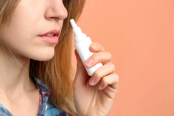 Mujer Joven Enferma Usando Aerosol Nasal Sobre Fondo Coral Primer —  Fotos de Stock