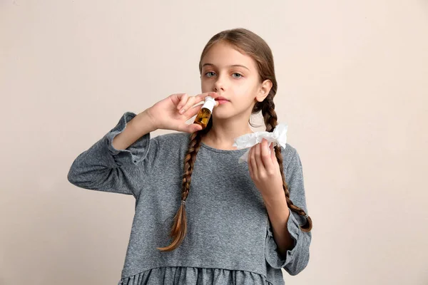 Άρρωστο Κοριτσάκι Χρησιμοποιώντας Ρινικό Σπρέι Μπεζ Φόντο — Φωτογραφία Αρχείου