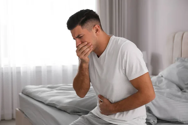 自宅のベッドで吐き気を催す男 食中毒 — ストック写真