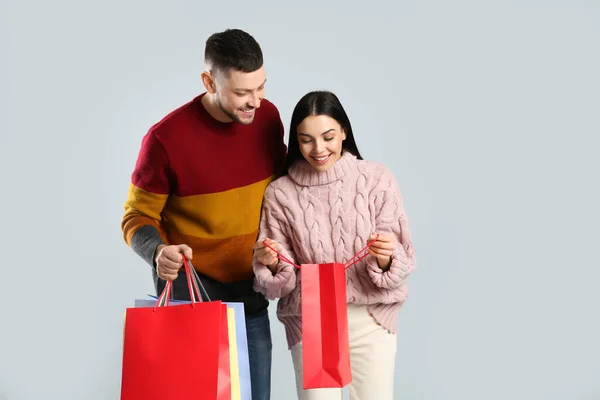 Joyeux Couple Avec Des Sacs Papier Sur Fond Gris Shopping — Photo