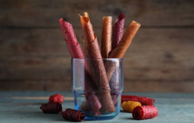 Lezzetli meyve derisi mavi ahşap masada yuvarlanıyor.