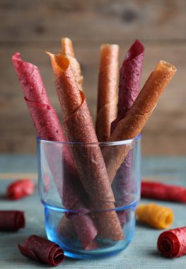 Lezzetli meyve derisi mavi ahşap masada yuvarlanıyor.