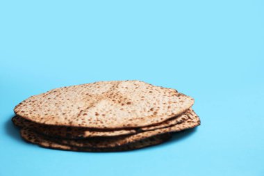 Açık mavi arkaplanda leziz matzolar, metin için boşluk. Hamursuz Bayramı (Pesach) kutlaması