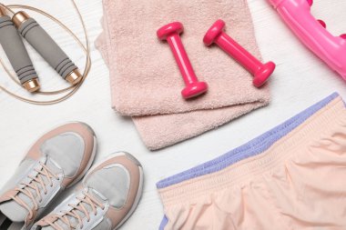 Beyaz ahşap arka planda spor ekipmanları ile düz kompozisyon