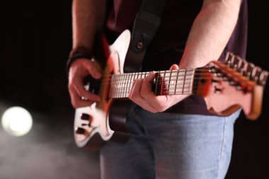 Sahnede elektro gitar çalan adam, yakın plan. Rock konseri