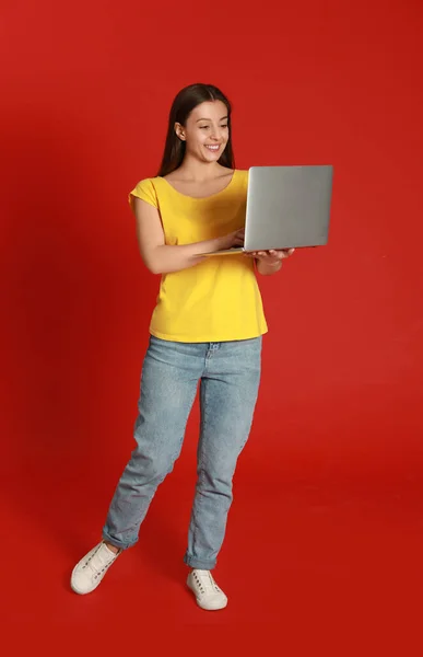 Młoda Kobieta Nowoczesnym Laptopem Czerwonym Tle — Zdjęcie stockowe