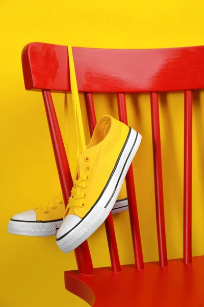 Par Zapatillas Colgadas Silla Cerca Pared Amarilla —  Fotos de Stock