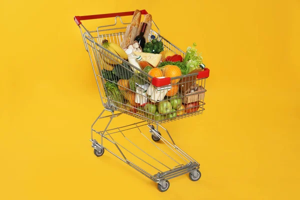 Einkaufswagen Voller Lebensmittel Auf Gelbem Hintergrund — Stockfoto
