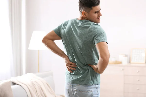 家で腰痛に苦しむ男 姿勢の悪い問題 — ストック写真