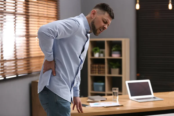 職場で腰痛に苦しむ男 姿勢不良の症状 — ストック写真