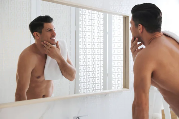 Bonito Homem Tocando Seu Rosto Liso Depois Barbear Perto Espelho — Fotografia de Stock