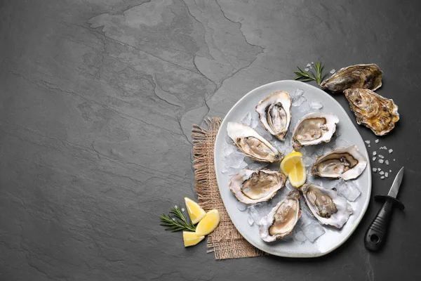 黒スレートテーブル フラットレイアウトで提供されるレモンスライスとおいしい新鮮な牡蠣 テキストのスペース — ストック写真