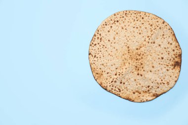 Açık mavi arkaplanda leziz bir matzo, metin için geniş bir manzarası var. Hamursuz Bayramı (Pesach) kutlaması