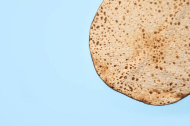 Açık mavi arkaplanda leziz bir matzo, metin için geniş bir manzarası var. Hamursuz Bayramı (Pesach) kutlaması