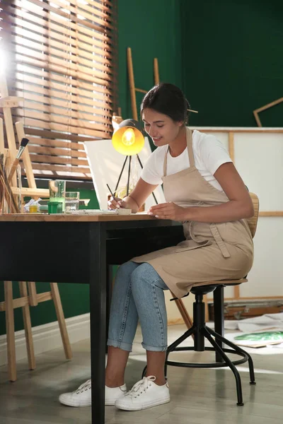 テーブルの屋内で水彩画を描く若い女性 — ストック写真