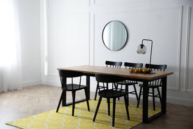 Şık ahşap yemek masası ve odada sandalyeler. İç tasarım