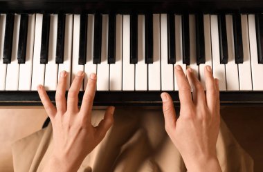 Piyano çalan genç bir kadın. Müzik dersi
