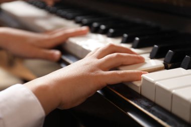 Küçük çocuk piyano çalıyor, yakın plan. Müzik dersi