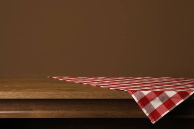 Ahşap masada kırmızı kareli tekstil peçetesi. Metin için boşluk