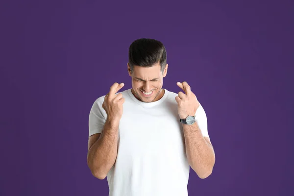 Man Crossed Fingers Purple Background Superstition Concept — Stock Photo, Image