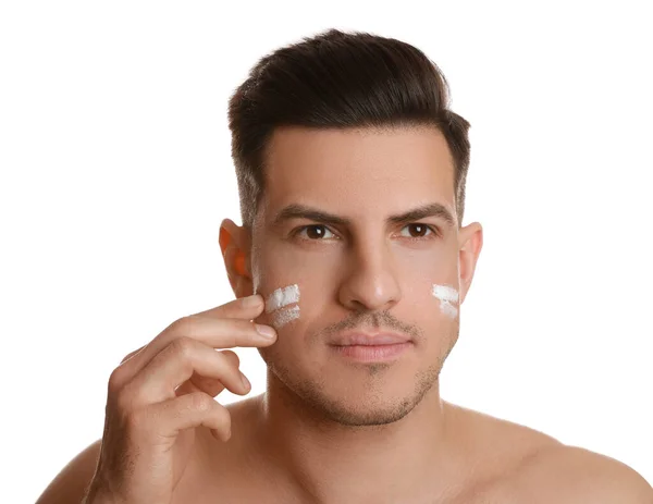 Bonito Homem Aplicando Creme Facial Fundo Branco — Fotografia de Stock