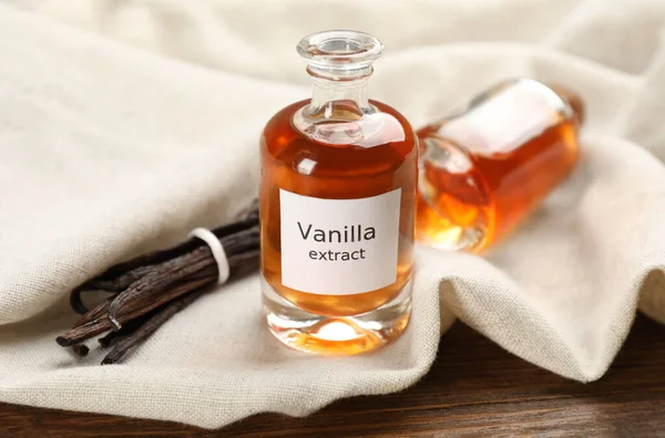 Aromatic vanilla extract and beans on table