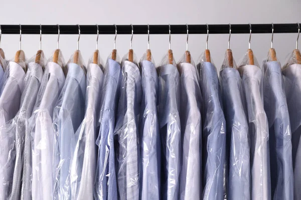 Cabides Com Camisas Sacos Plástico Limpeza Seco Rack Contra Fundo — Fotografia de Stock