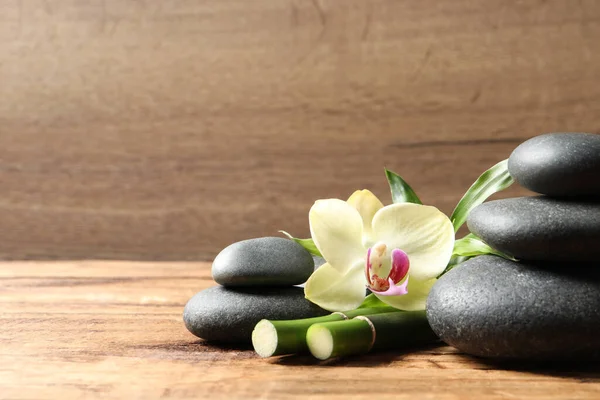 Wellness Steine Bambusstämme Und Schöne Orchideenblume Auf Holztisch Platz Für — Stockfoto