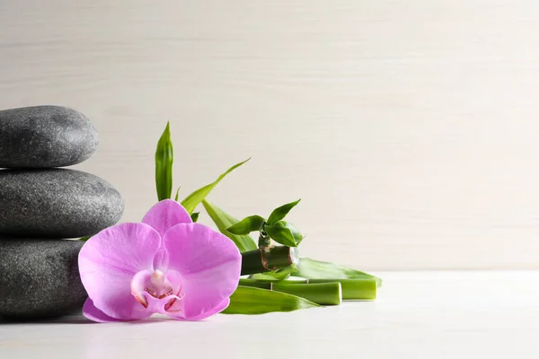 Wellness Steine Bambusstämme Und Schöne Orchideenblume Auf Weißem Tisch Platz — Stockfoto