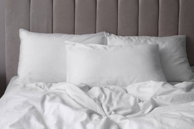 İçerideki rahat yatakta beyaz yumuşak yastıklar.