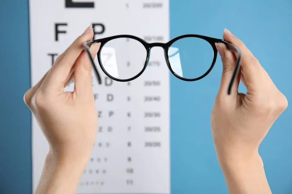 Woman Holding Glasses Eye Chart Blue Background Closeup Ophthalmologist Prescription — Stock Photo, Image