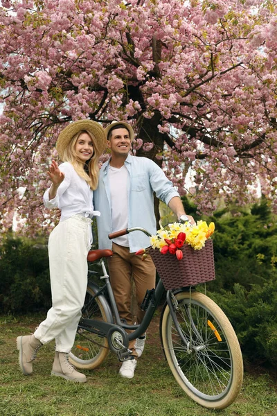 Piękna Para Rowerem Kwiatami Parku Przyjemny Wiosenny Dzień — Zdjęcie stockowe