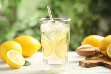 Serin taze limonata ve beyaz ahşap masada meyveler, yakın plan.